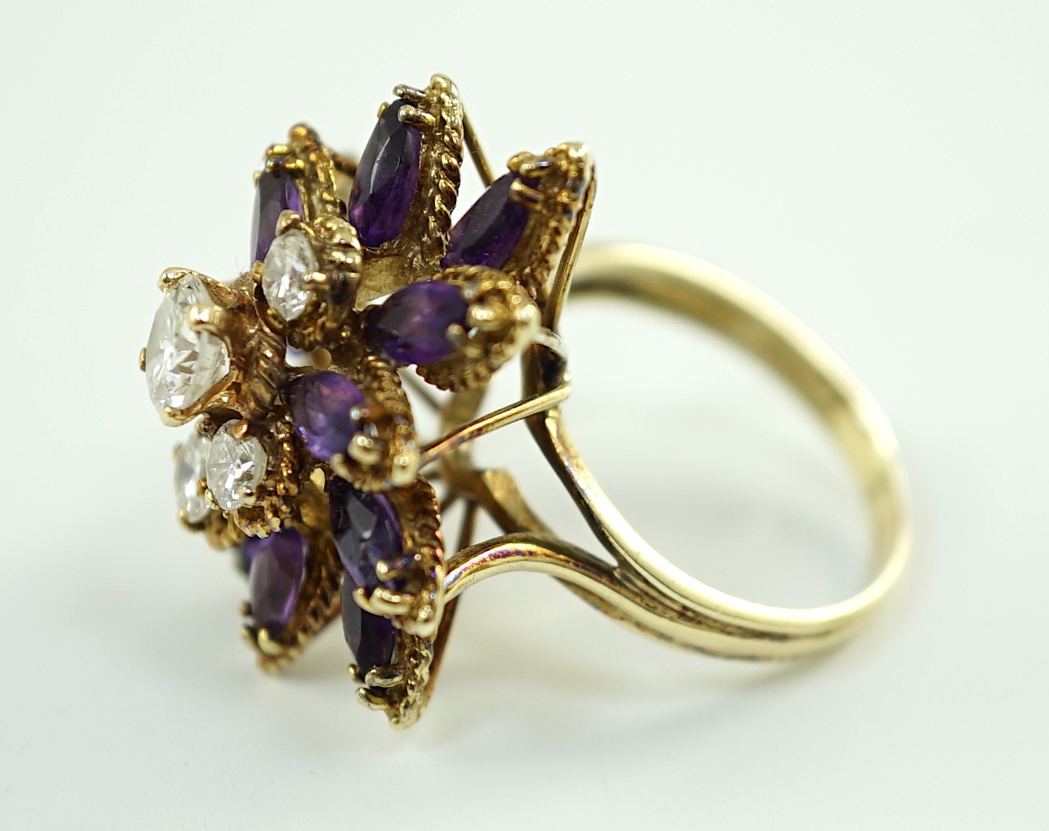A 14k gold, five stone graduated round cut diamond and twelve stone marquise cut amethyst set cluster dress ring